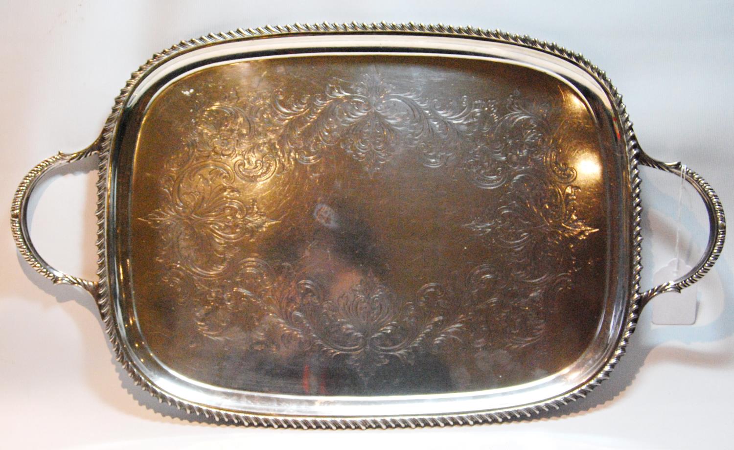 Silver tray of bowed rectangular shape with engraved scrolls, gadrooned border and handles,