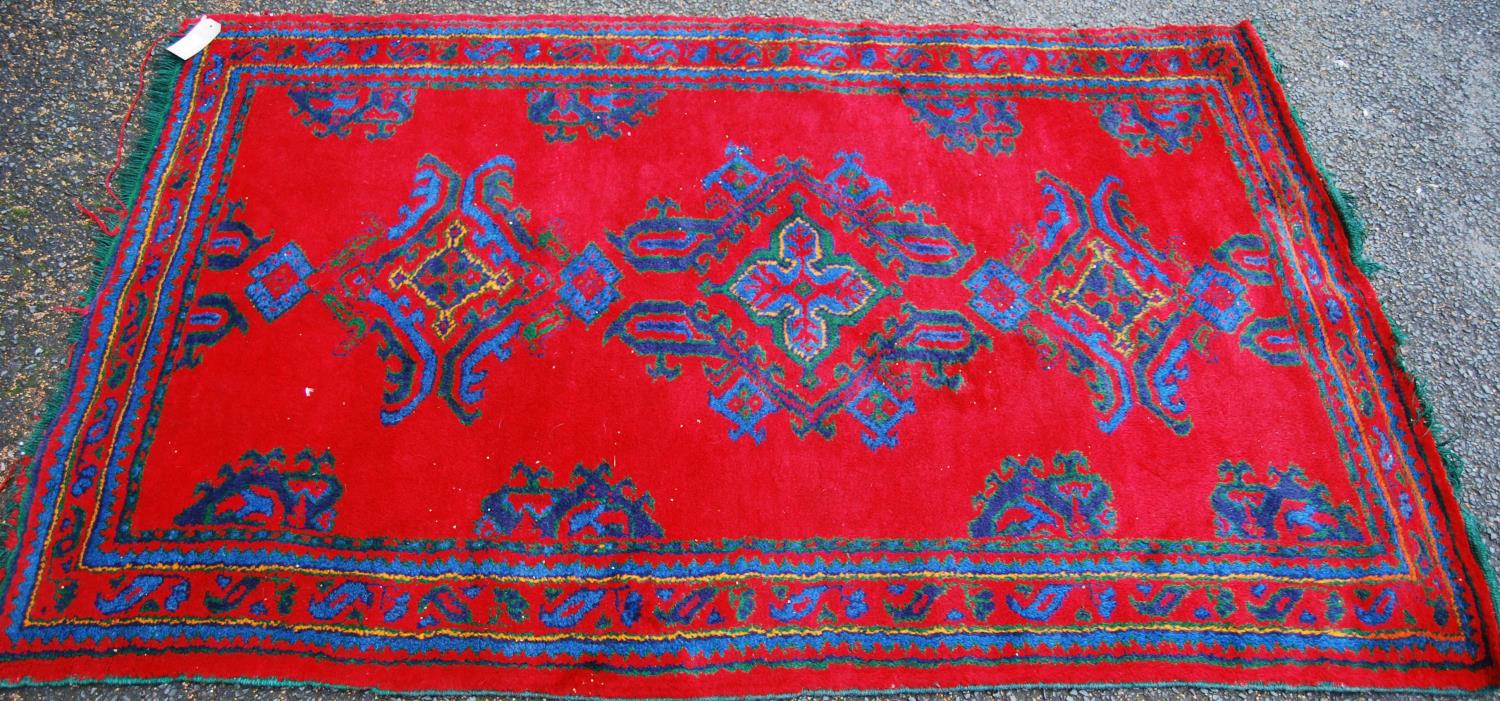 Turkoman rug with three cruciform lozenges over red ground and border, 198cm x 125cm.