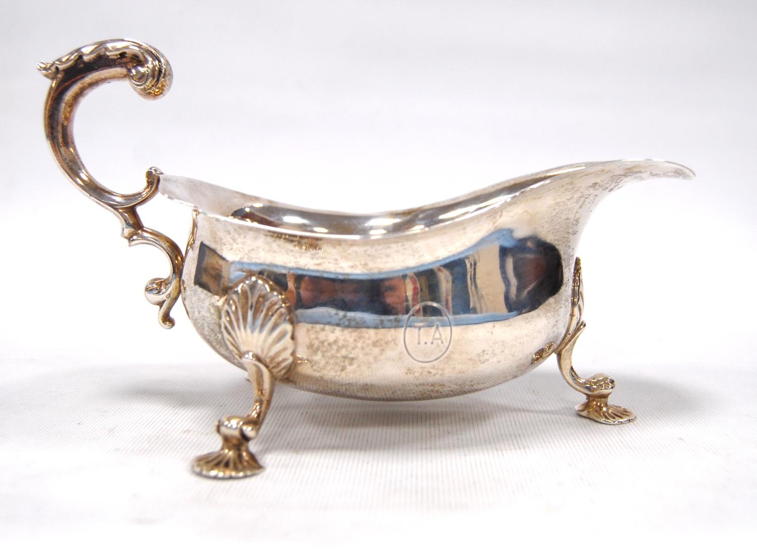 Silver sauce boat on tripod legs terminating in scallop feet, possibly by Wakely & Wheeler, London