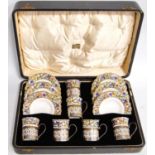 Cased coffee set by Aynsley with floral decoration, the cups with Birmingham silver handles,