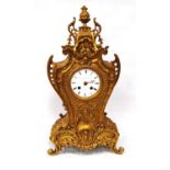 Gilt metal mantel clock by Promoli & Hausburg, Paris, mounted by finial with scrolling brackets