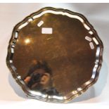 Silver circular tray with shaped, moulded edge, initialled, on claw and ball feet, by Viners,