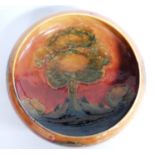 Tudric Moorcroft Eventide pattern bowl decorated with trees, orange and green glazes and raised on a