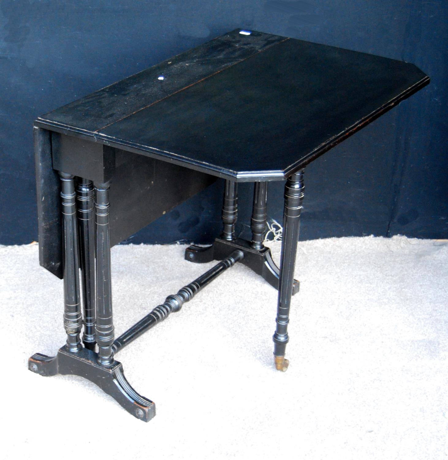 Victorian ebonised Sutherland table, the moulded rectangular top with canted corners, raised on