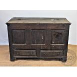 An 18th century oak mule chest, with panelled front and two drawers, on stile feet,