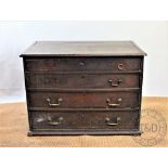 A George III oak chest, with four graduated long drawers, lacking feet,