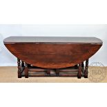 An 18th century style oak wake type table, the oval table on turned legs and block feet,