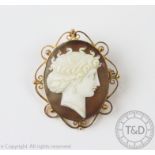 A carved shell cameo brooch, the oval brooch depicting a classical maiden in profile,