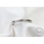 A diamond set platinum half eternity ring, channel set with fifteen brilliant cut diamonds,