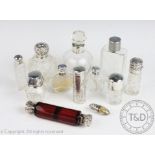 A collection of assorted silver and silver mounted scent bottles and jars,