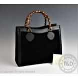 A Gucci black leather, suede and bamboo handbag with goldtone hardware, interior labelled 'Gucci,
