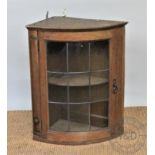 An Edwardian carved oak hanging corner cabinet, of small proportions,