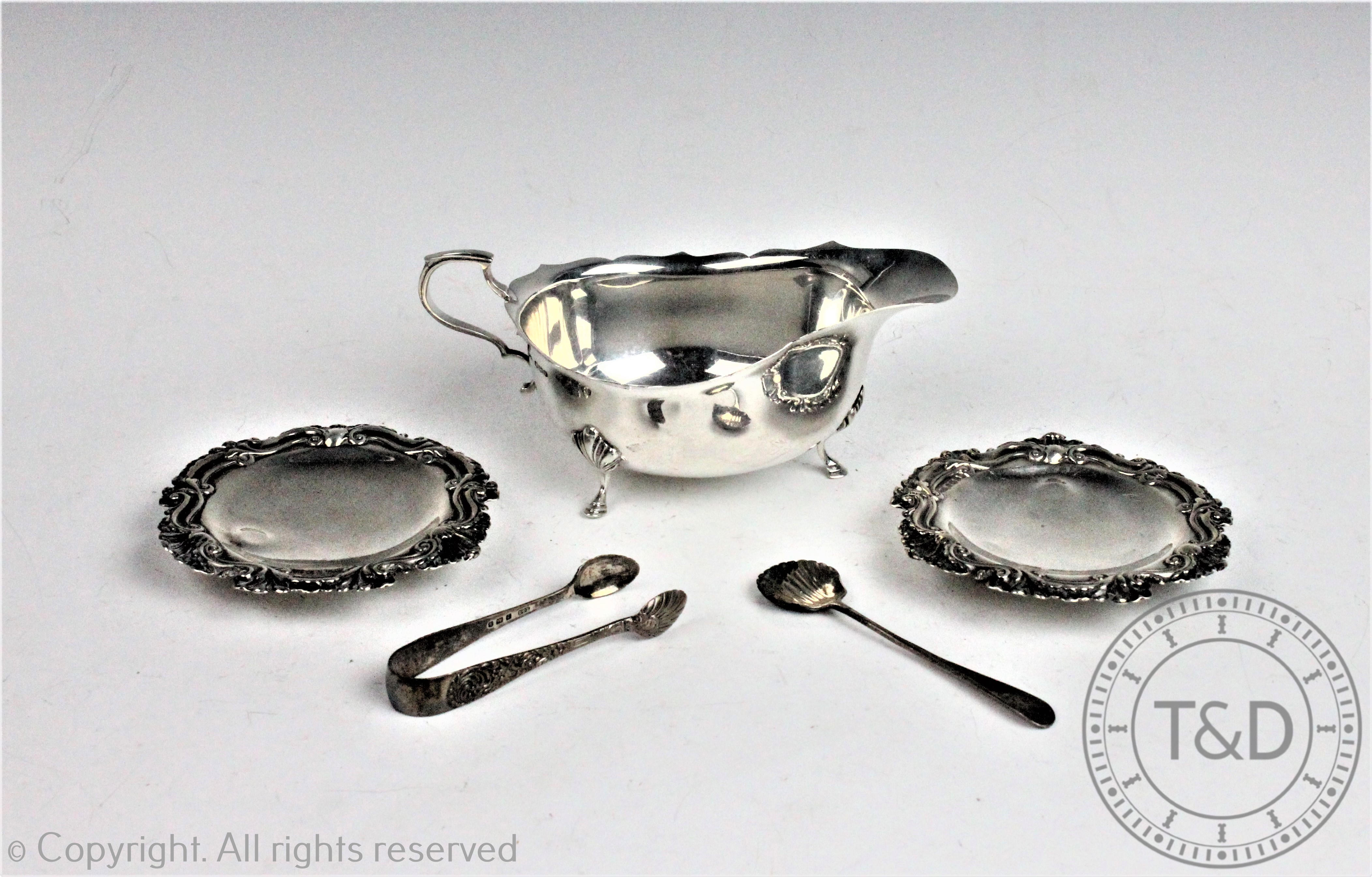 A George VI silver sauce boat, Sheffield 1948, with a pair of embossed silver dishes,