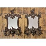 A pair of early 20th century French mirror back bronzed wall sconces,