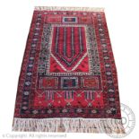 A Persian wool prayer mat, worked with stylised geometric motifs,