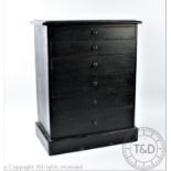 A late Victorian ebonised table top collectors chest of six graduated drawers, on plinth base,