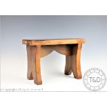 An oak jointed stool, in the Mouseman style, the rectangular top carved with a mouse to each side,