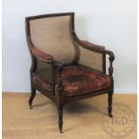 A George IV carved mahogany library chair, with a curved back inset with curved caning,