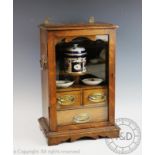 An Edwardian oak smokers cabinet, with glazed door enclosing a fitted interior, 43.