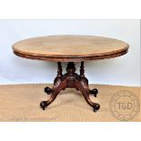 A Victorian walnut oval loo table, with turned column supports,