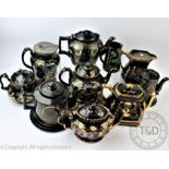 A collection of ten Victorian gilt black teapots and jugs,