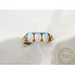 A three stone opal ring, the three oval, untested opals all set in 9ct yellow gold,