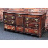 An 18th century oak mule chest, with hinged top above four dummy and three real drawers,