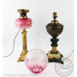 A Victorian gilt metal and pink glass oil lamp, converted to electricity, with fluted column,