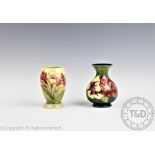 A Moorcroft Hibiscus pattern vase decorated with claret and yellow blooms against a green ground,