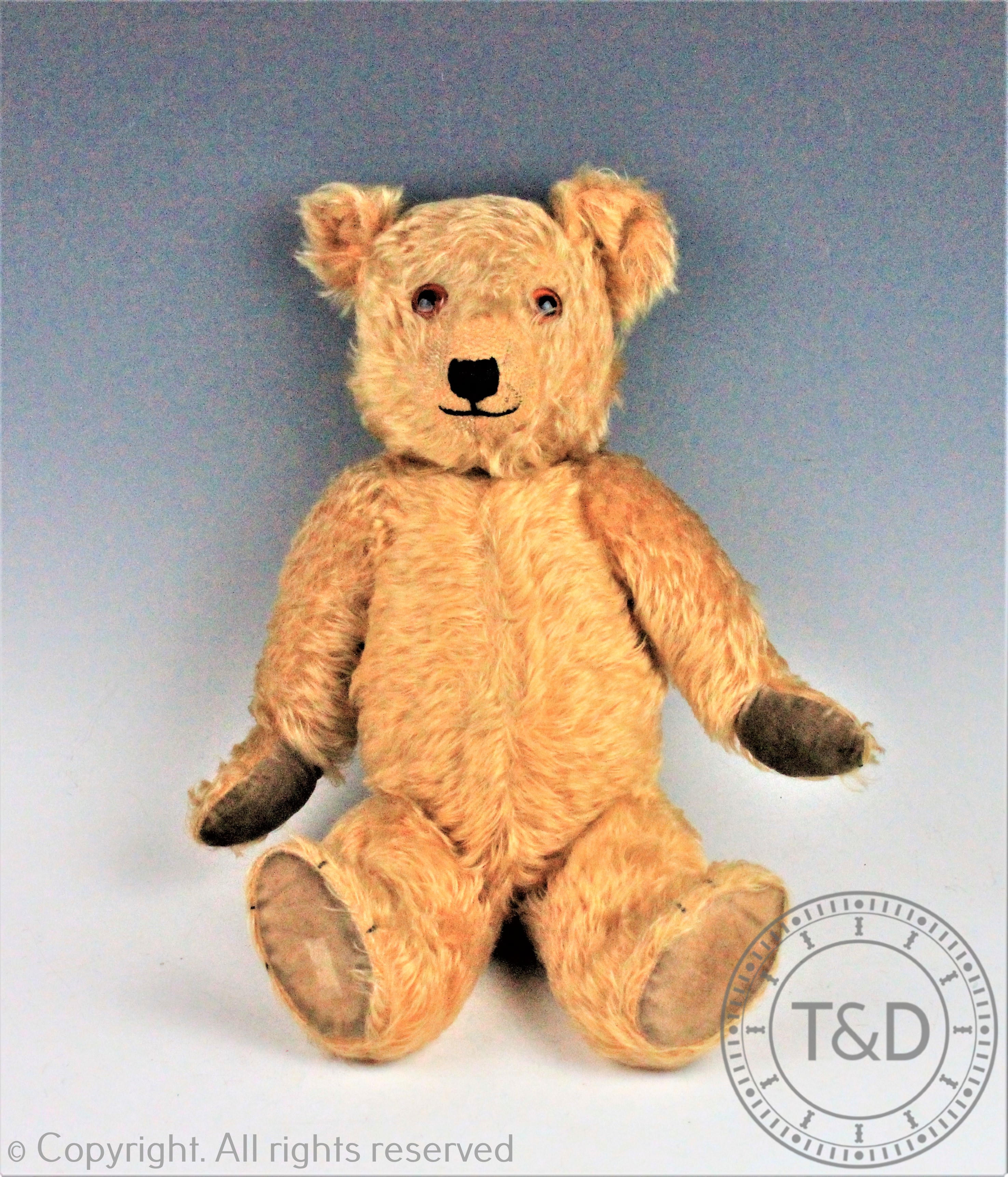 A Chiltern 'Hug-me' bear, golden plush, articulated limbs and rotating head with glass eyes,