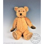 A Chiltern 'Hug-me' bear, golden plush, articulated limbs and rotating head with glass eyes,