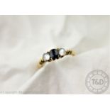 A sapphire and moonstone three stone ring in 18ct gold,