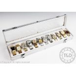 A case containing an assorted collection of gold coloured and stainless steel wristwatches,