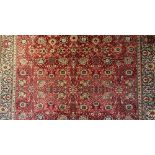 A machine woven Kandahar type carpet, worked with an all over floral design against a red ground,