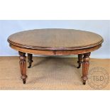 A Victorian oval oak extending dining table,