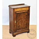 An Edwardian inlaid oak cupboard, with panelled door, on bracket feet, 85cm H x 57cm W x 31cm D,