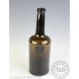 An 18th century green glass wine bottle with moulded seal to front 'James Okes Bury 1777' - with