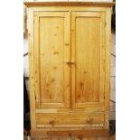 A pine wardrobe, with two doors and base drawer, on plinth base,