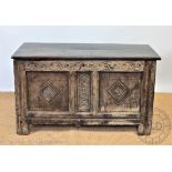An early 18th century oak coffer, with later carved detailing, on stile feet,
