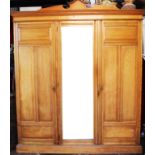 An Edwardian ash three door wardrobe, of architectural form, with three press trays and two drawers,