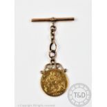 A George V gold sovereign dated 1927, with scroll mount and attached T bar stamped '9ct',