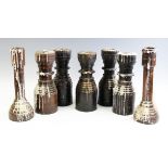 Seven turned and stained wood gothic inspired candlesticks, comprising a pair, 33.