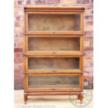 A Globe Wernicke walnut four section bookcase, with label to one section, on plinth base,