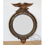 A Regency style gilt wood and composite convex wall mirror, early 20th century, with eagle surmount,