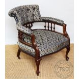 An Edwardian carved walnut tub chair, with button back blue foliate upholstery, on cabriole legs,