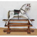 A dappled grey rocking horse attributed to Ayres, with leather seat, on pine stand,