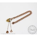 A 9ct rose gold slender curb link bracelet with an attached padlock clasp, gross weight 12.