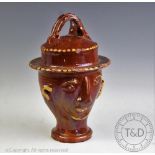 A late 19th century novelty slipware puzzle jug in the form of a head,