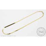 A yellow metal snake link chain, of uniform width with engraved detailing,