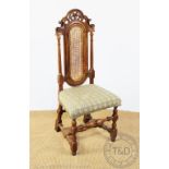 An early 20th century Carolean style carved walnut chair, with caned back and upholstered seat,